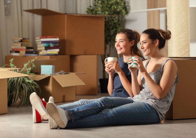 Two girls sitting by boxes