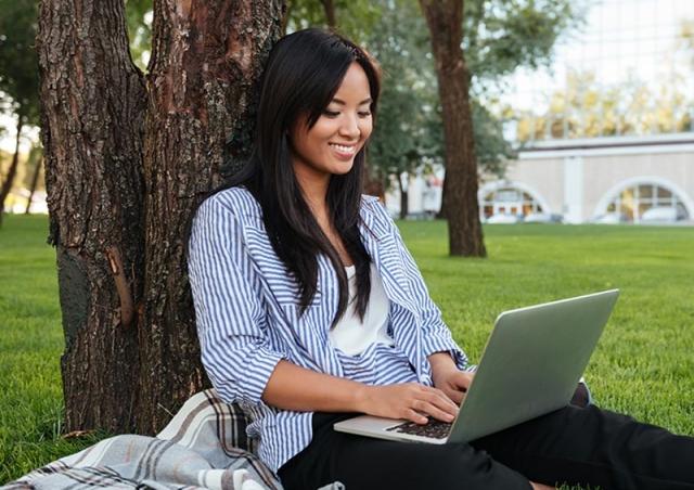 Woman outside looking at computer