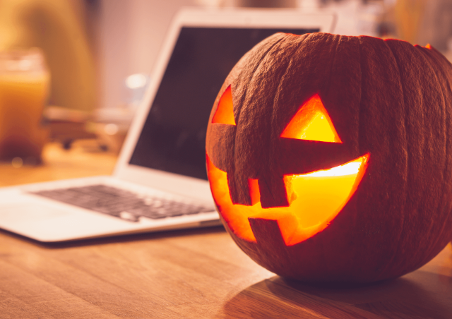 Jack-o-lantern next to a laptop